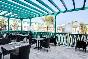 Terrasse des Barceló Teguise Beach Adults Only Hotels mit Tischen und Stühlen
