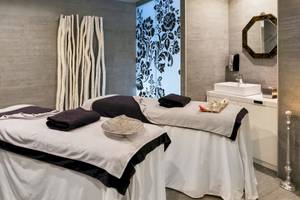 Spa-Behandlungsraum im Barceló Teguise Beach Adults Only Hotel mit zwei Massagetischen und einem Waschbecken.