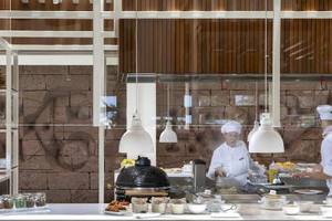 Küche des Melia Salinas Hotels mit Köchen, die Essen zubereiten und verschiedene Gerichte servieren.