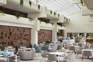 Lobby des Melia Salinas Hotels mit vielen Stühlen, Tischen und Pflanzen.