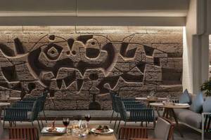Inneneinrichtung des Melia Salinas Hotels mit einem großen Wandbild und runden Tischen.