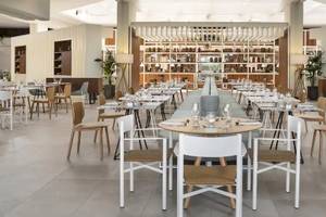 Innenansicht des Restaurants im Melia Salinas Hotel mit leeren Tischen, Stühlen und Regalen.