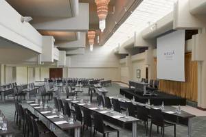 Konferenzsaal im Melia Salinas Hotel mit vielen Tischen, Stühlen und einer Leinwand