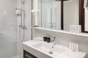 Badezimmer im Melia Salinas Hotel mit ebenerdiger Dusche, Waschbecken und Spiegel.