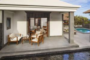 Außenbereich der Melia Salinas Pool Suite mit Terrasse, Möbeln und Pool.