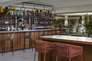 Innenansicht der Bar im Melia Salinas Hotel mit Barhockern, Holztheke und Regalen voller Flaschen.
