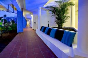 Innenbereich des Dreams Lanzarote Playa Dorada Resort & Spa mit blau beleuchteten Flur und bequemen Sitzbänken.