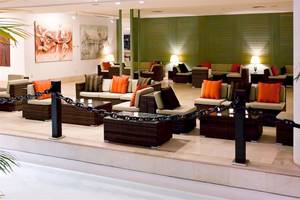 Loungebereich im Dreams Lanzarote Playa Dorada Resort & Spa mit braunen Sofas und grünen Wänden.