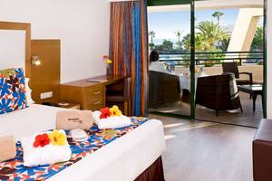 Zimmer im Dreams Lanzarote Playa Dorada Resort & Spa mit Blick auf einen Pool und Palmen.