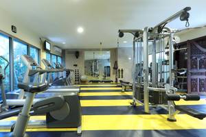 Fitnesscenter im Iberostar Grand Paraiso Hotel mit Laufbändern, Kraftgeräten und großen Fenstern.
