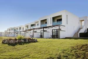 Außenansicht des Club Plimmiri Hotels mit weißen Gebäuden und grünem Rasen