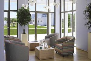 Lobby des Club Plimmiri Hotels mit großen Fenstern, modernen Möbeln und Pflanzen.