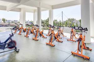 Reihe von orangefarbenen Fahrradtrainern im Freien im Club Plimmiri Hotel.