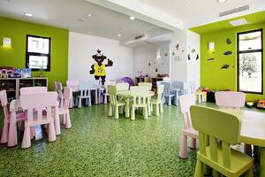 Kinderspielzimmer im Club Plimmiri Hotel mit grünen Wänden, bunten Möbeln und Spielsachen.