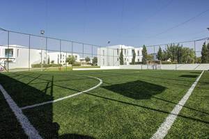 Fussballplatz im Club Plimmiri Hotel mit weißem Zaun und grünem Rasen