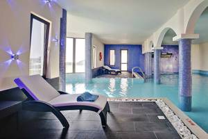 Pool-Loungebereich im Club Plimmiri Hotel mit blauen Säulen und Liegestühlen.