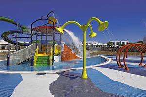 Wasserspielplatz im Club Plimmiri Hotel mit bunten Rutschen und Wasserfontaenen.