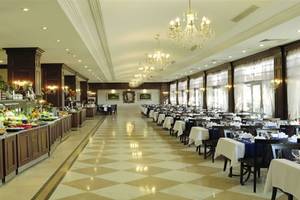Innenansicht des Restaurants im Club Cactus Paradise Hotel mit gemustertem Boden, gedeckten Tischen und einer langen Salatbar.
