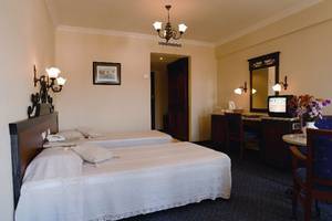 Doppelzimmer im Club Cactus Paradise Hotel mit zwei Betten, Schreibtisch und Fernseher.