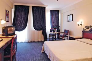 Hotelzimmer im Club Cactus Paradise mit Doppelbett, Fernseher und Schreibtisch.