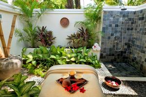 Außenbereich des Kurumba Maldives Hotels mit einer Spa-Behandlung und Pflanzen.