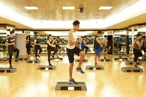 Gruppe von Menschen, die in einem Fitnessstudio des Pathumwan Princess Hotels trainieren.