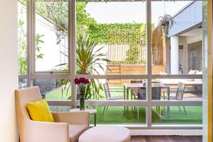 Innenansicht des Pathumwan Princess Hotels durch große Fenster mit Gartenblick