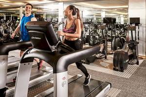 Fitnessstudio im Pathumwan Princess Hotel mit Männern und Frauen auf Laufbändern
