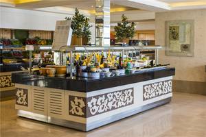 Buffettisch im Voyage Torba Hotel mit verschiedenen Gerichten und Pflanzen.
