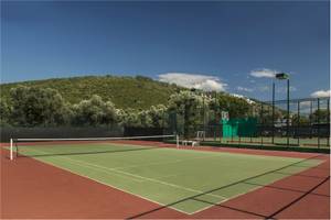 Tennisplatz im Voyage Torba Hotel mit grünem Platz und roten Seitenbereichen.