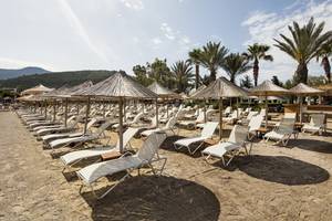 Strand des Voyage Torba Hotels mit vielen Sonnenliegen und Sonnenschirmen