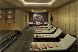 Spa-Behandlungsraum im Hotel Voyage Torba mit Liegen und Holzmöbeln.
