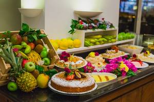 Frühstücksbuffet im Napa Plaza Hotel mit verschiedenen Früchten und Desserts.
