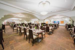 Innenbereich des Napa Plaza Hotels mit Restaurantbereich, gedeckten Tischen und hohen Decken.