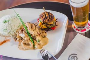 Essen und Getränk im Napa Plaza Hotel: Ein Teller mit Reis, Huhn und einem Burger.
