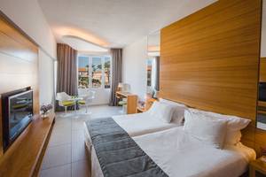 Innenansicht eines Doppelzimmers im Napa Plaza Hotel mit zwei Betten, einem Fernseher und einem Schreibtisch.