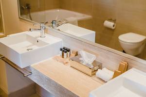 Badezimmer im Napa Plaza Hotel mit Waschbecken, Toilette und Spiegel