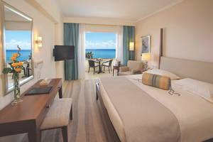 Zimmer im Alexander The Great Hotel mit Meerblick, Bett, Fernseher, Schreibtisch und Balkon