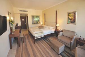 Hotelzimmer von Alexander The Great mit Doppelbett, Nachttischen, Fernseher und Dekor.