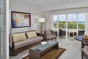 Hotelzimmer mit Meerblick und Balkon, inklusive Wohnzimmer und Esstisch.