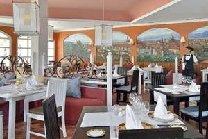 Innenansicht des Paradisus Princesa del Mar Restaurants mit einer Kellnerin, die eine Tischplatte bedient.