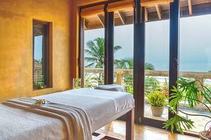 Massageraum im Jetwing Sea Hotel mit Blick auf das Meer und Palmen.