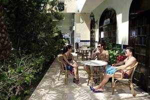 Drei Gäste sitzen auf der Terrasse des Hotels Rey Carlos und unterhalten sich.