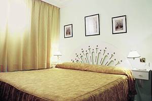 Doppelbett im Hotelzimmer des Rey Carlos mit drei Bildern an der Wand