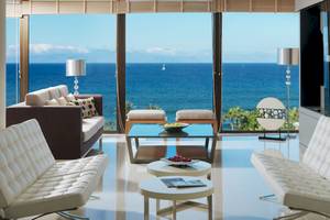 Wohnzimmer des H10 Conquistador Hotels mit Blick auf das Meer und einen Segelboot.