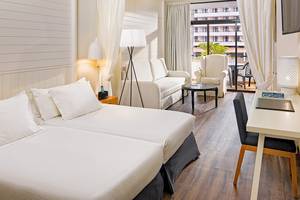 Innenansicht eines Doppelzimmers im H10 Conquistador Hotel mit zwei Betten, Schreibtisch und Balkon.