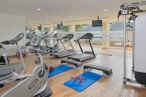 Fitnessstudio im H10 Conquistador Hotel mit verschiedenen Trainingsgeräten und Gewichten.