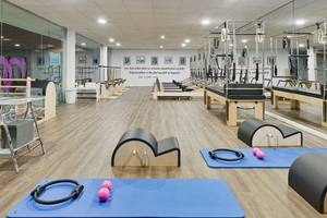 Fitnessstudio des H10 Conquistador Hotels mit Pilatesgeräten, Matten und Gewichten.