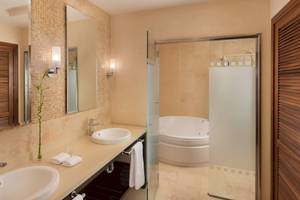 Badezimmer mit zwei Waschbecken, einer Badewanne und einer Glasdusche.