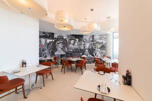 Innenansicht des Ramla Bay Resorts Restaurant mit einer Wand voller Fotocollagen.